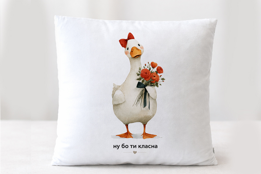 Подушка подарункова плюшева біла з малюнком білої гуски з червоним бвнтиком,яка тримає букет червоних квітів, внизу напис: Ну бо ти класна.Розмір 35*35